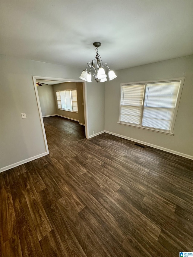 unfurnished dining area featuring dark hardwood / wood-style floors and an inviting chandelier