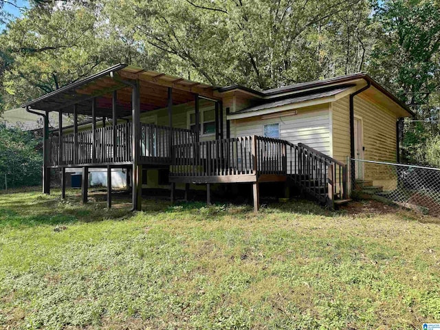 rear view of house with a deck and a lawn