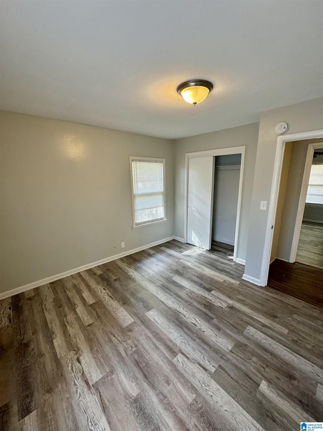 unfurnished bedroom featuring a closet and hardwood / wood-style floors