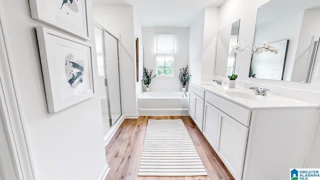 bathroom featuring hardwood / wood-style floors, vanity, and shower with separate bathtub