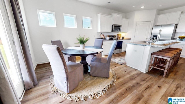 dining space featuring light hardwood / wood-style flooring and sink