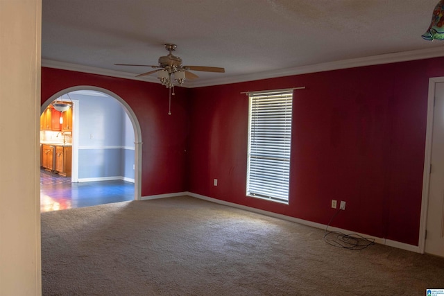 empty room with carpet, a textured ceiling, ceiling fan, and ornamental molding