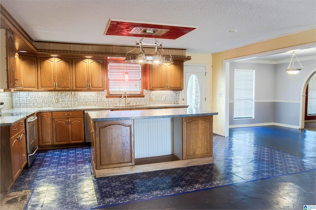 kitchen with decorative backsplash, pendant lighting, a textured ceiling, and a kitchen island