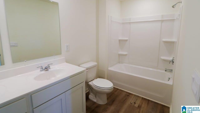 full bathroom with hardwood / wood-style floors, vanity, shower / bath combination, and toilet