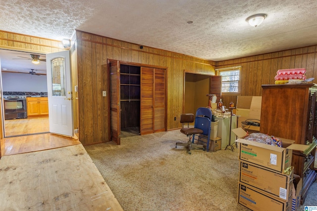 office space with a textured ceiling, ceiling fan, and light carpet