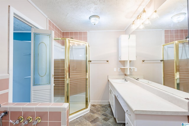 bathroom featuring a textured ceiling, vanity, and walk in shower