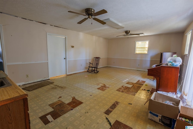 unfurnished room with ceiling fan and a textured ceiling