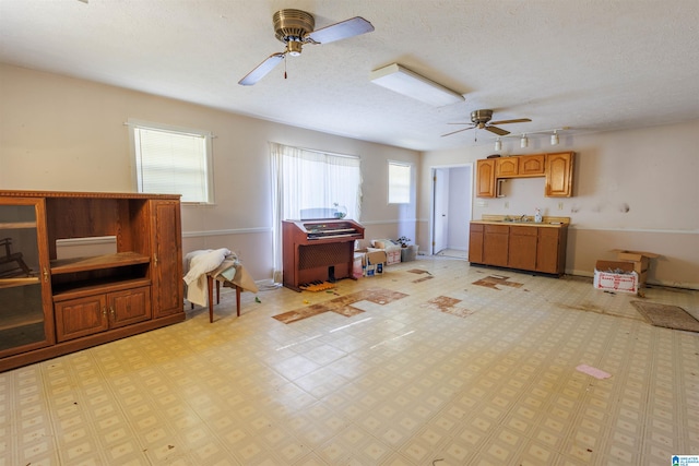 misc room featuring ceiling fan, a healthy amount of sunlight, and a textured ceiling