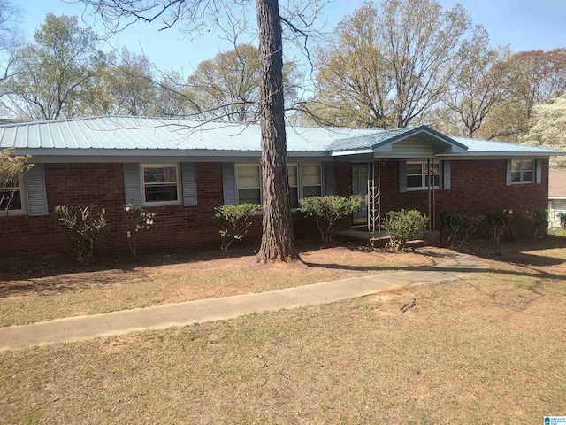 694 Center Point Rd, Sylacauga, AL 35151 - ranch-style house with a front yard, brick siding, and metal roof