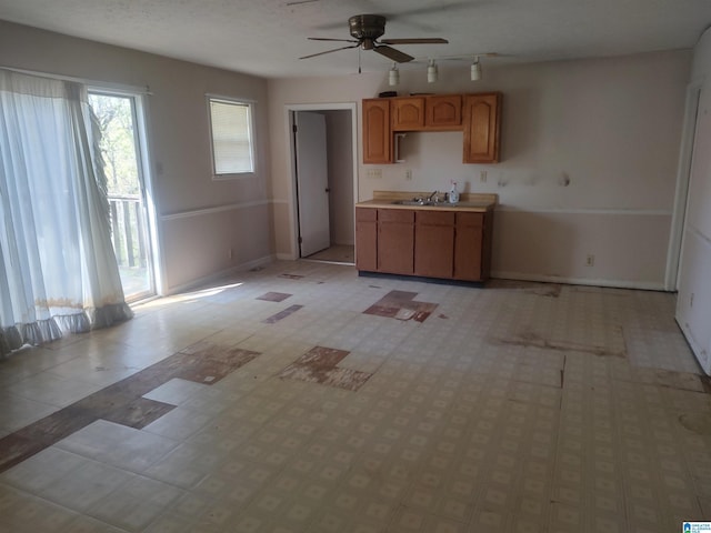 694 Center Point Rd, Sylacauga, AL 35151 - kitchen featuring a ceiling fan, baseboards, light countertops, and a sink