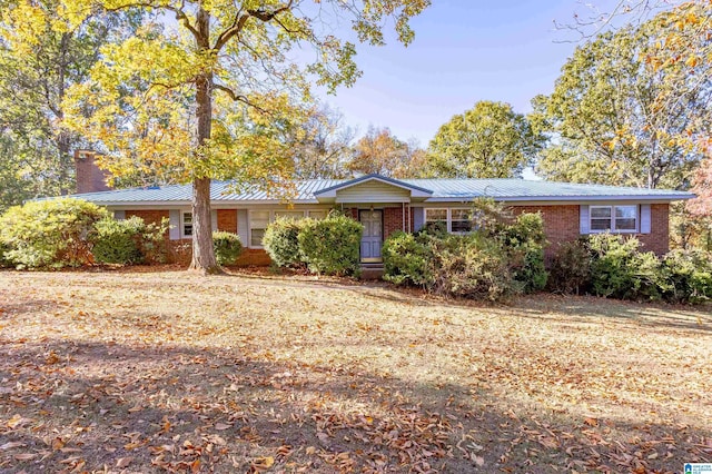 694 Center Point Rd, Sylacauga, AL 35151 - ranch-style house with brick siding, metal roof, a chimney, and a standing seam roof