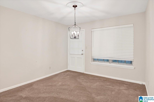 carpeted empty room with a chandelier