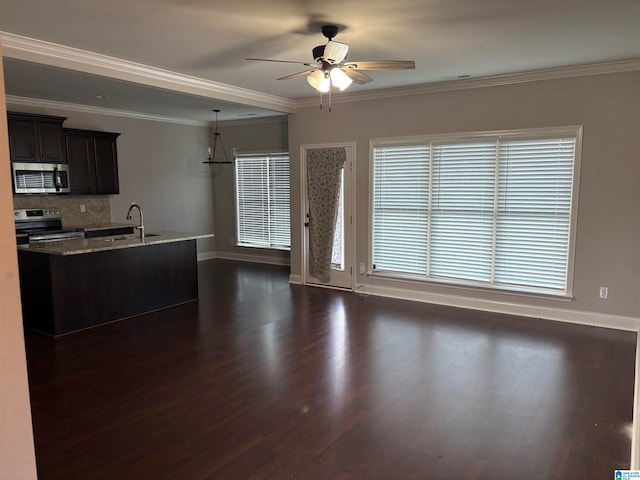 kitchen featuring light stone counters, dark hardwood / wood-style flooring, stainless steel appliances, and ornamental molding