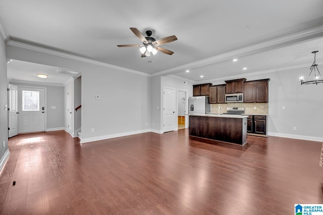 unfurnished living room featuring sink, ceiling fan with notable chandelier, crown molding, and dark wood-type flooring