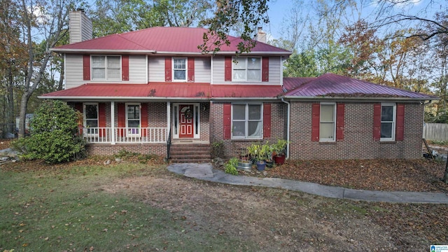 130 Big Oak Dr, Maylene, AL 35114 - view of front of property featuring a chimney, a porch, metal roof, brick siding, and a front yard