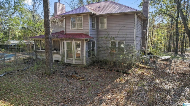 130 Big Oak Dr, Maylene, AL 35114 - rear view of house with a chimney, a sunroom, fence, and metal roof