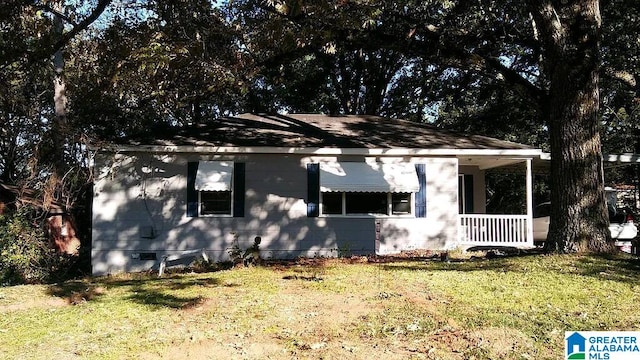 view of side of home with a lawn and a porch