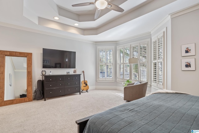 carpeted bedroom featuring a raised ceiling, ceiling fan, and crown molding