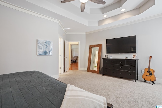 carpeted bedroom with ceiling fan, a raised ceiling, and ornamental molding