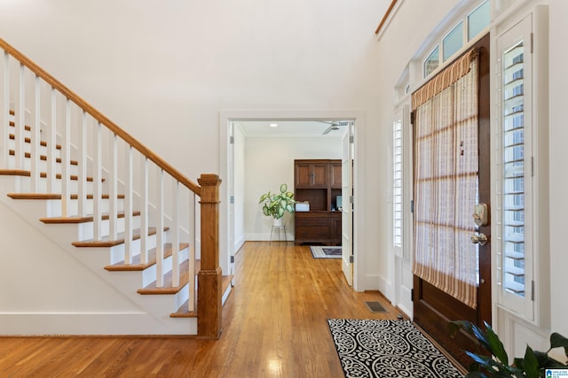 entryway with hardwood / wood-style floors, a healthy amount of sunlight, and crown molding