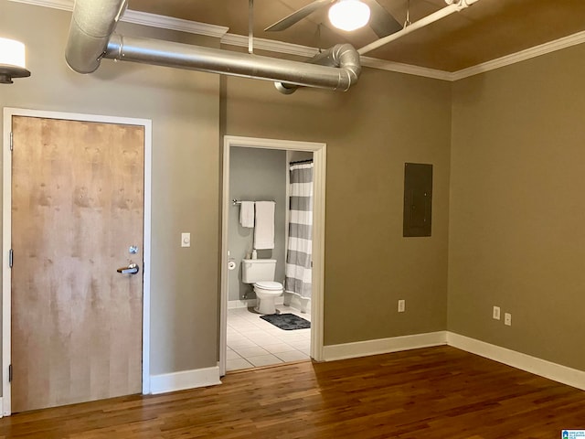 unfurnished bedroom with hardwood / wood-style floors, connected bathroom, electric panel, and crown molding