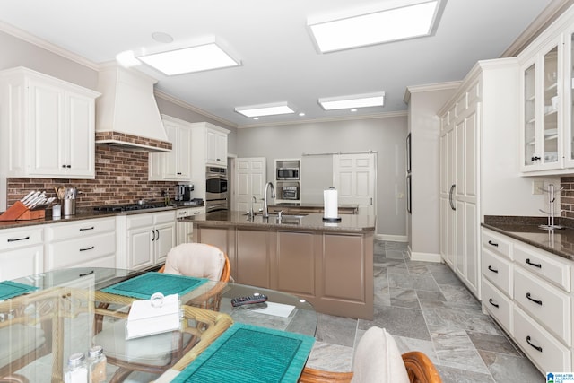 kitchen featuring ornamental molding, dark stone counters, custom range hood, black gas cooktop, and white cabinetry