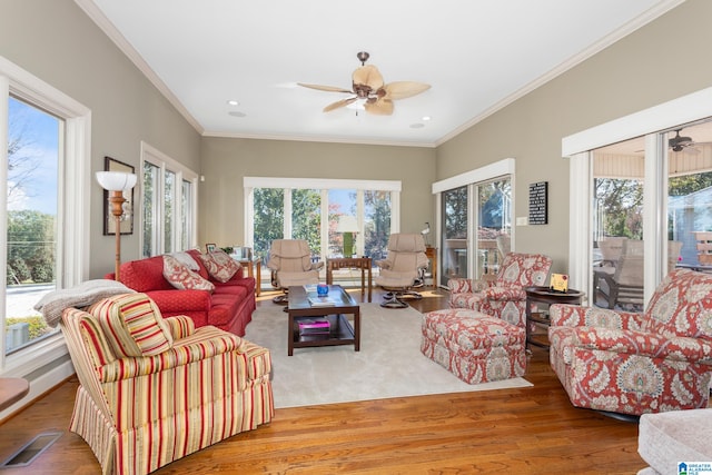 living room with hardwood / wood-style floors, plenty of natural light, ceiling fan, and ornamental molding