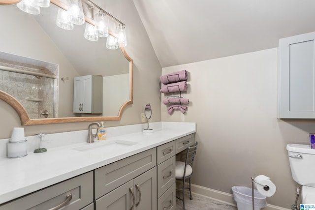 bathroom featuring vanity, toilet, lofted ceiling, and a shower with door