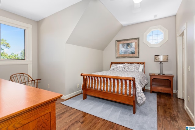 bedroom featuring dark hardwood / wood-style flooring, vaulted ceiling, and ceiling fan