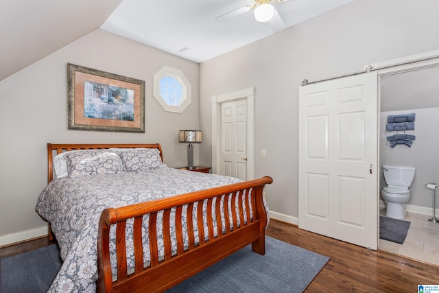 bedroom with ceiling fan, dark wood-type flooring, connected bathroom, and vaulted ceiling