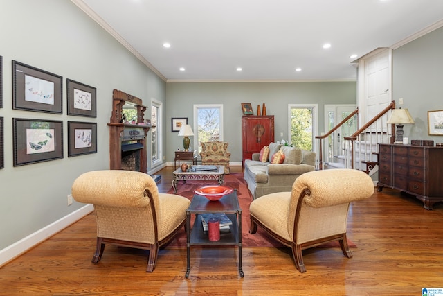 living room with hardwood / wood-style floors, plenty of natural light, and ornamental molding