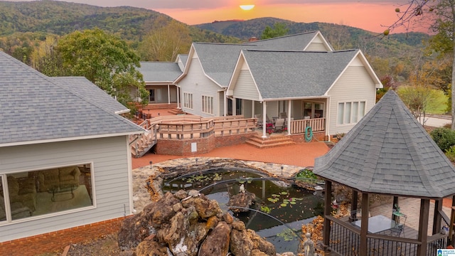 1001 Kingsway Dr, Anniston, AL 36207 - back of property at dusk with a gazebo, a mountain view, and roof with shingles