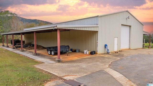 outdoor structure at dusk with a carport and a mountain view