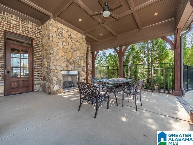 view of patio / terrace with an outdoor stone fireplace and ceiling fan