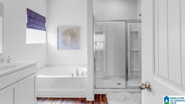 bathroom featuring vanity, wood-type flooring, and shower with separate bathtub