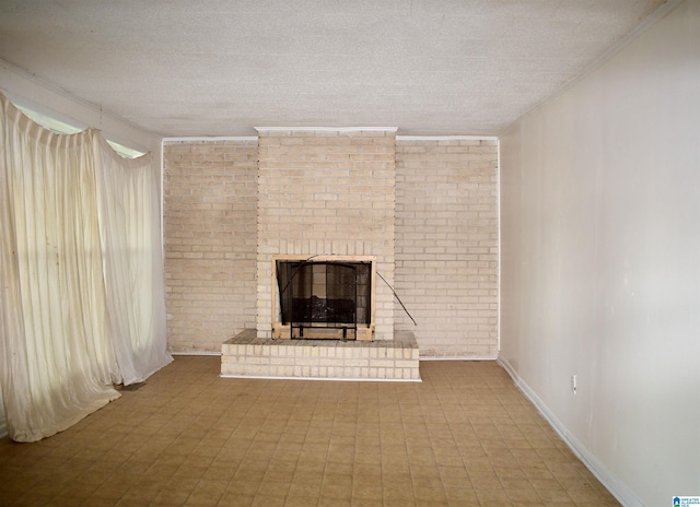 unfurnished living room featuring a textured ceiling, a fireplace, and brick wall