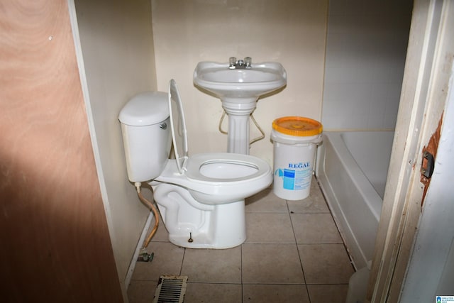 bathroom featuring a bathing tub, tile patterned flooring, and toilet