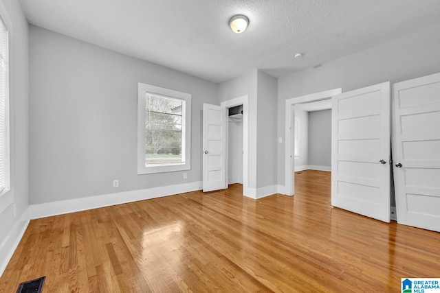 unfurnished bedroom with wood-type flooring and a textured ceiling