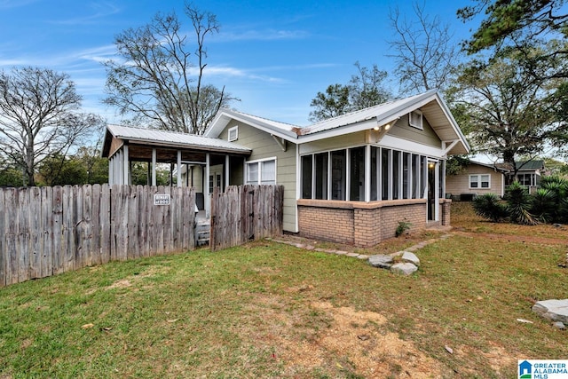 exterior space featuring a yard and a sunroom