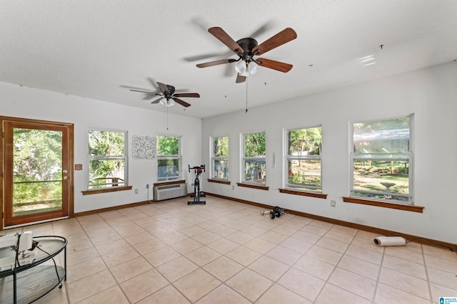 interior space featuring ceiling fan, a healthy amount of sunlight, light tile patterned flooring, and a textured ceiling