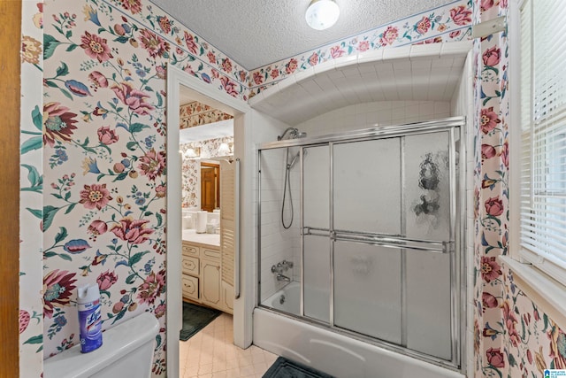 full bathroom featuring vanity, tile patterned flooring, toilet, enclosed tub / shower combo, and a textured ceiling