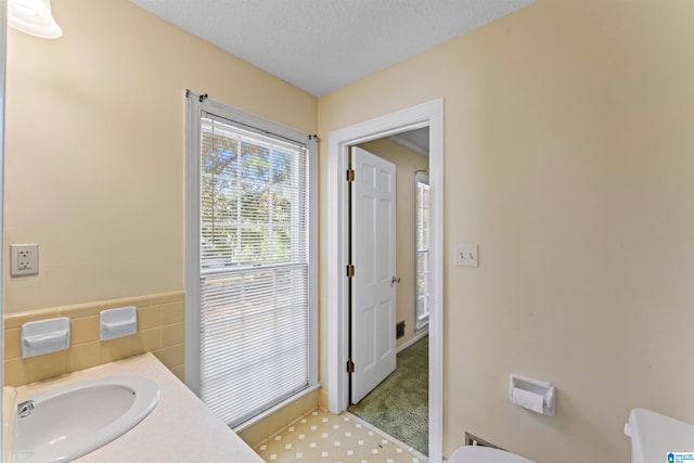 bathroom with vanity, a textured ceiling, and toilet