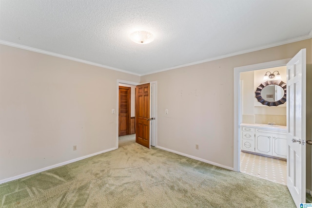 unfurnished room with a textured ceiling, light colored carpet, crown molding, and sink