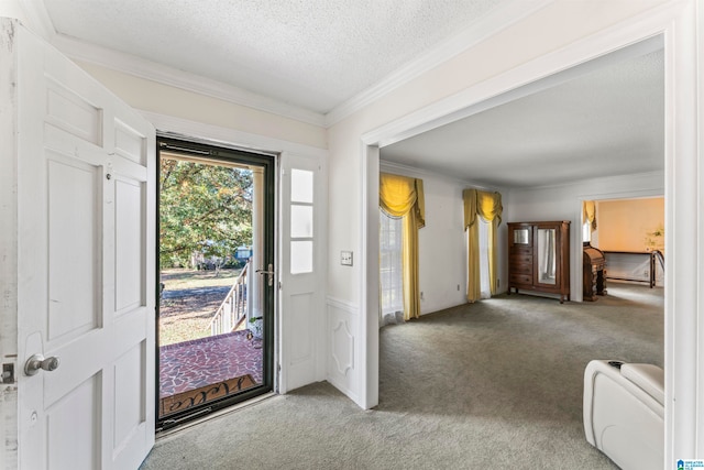 carpeted entryway with a textured ceiling and ornamental molding