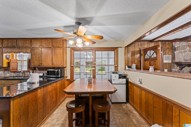 kitchen with a textured ceiling, decorative backsplash, and wood walls