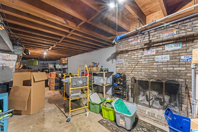 basement featuring brick wall and a brick fireplace