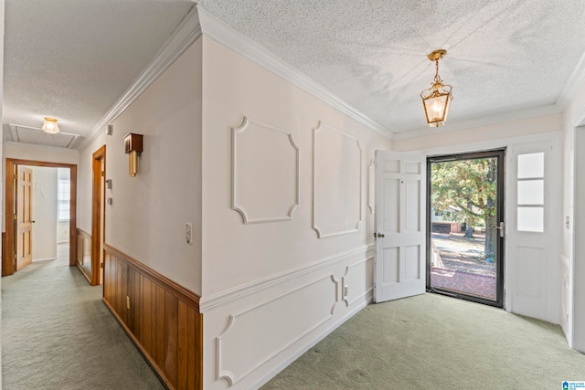 foyer with light carpet, a textured ceiling, and crown molding