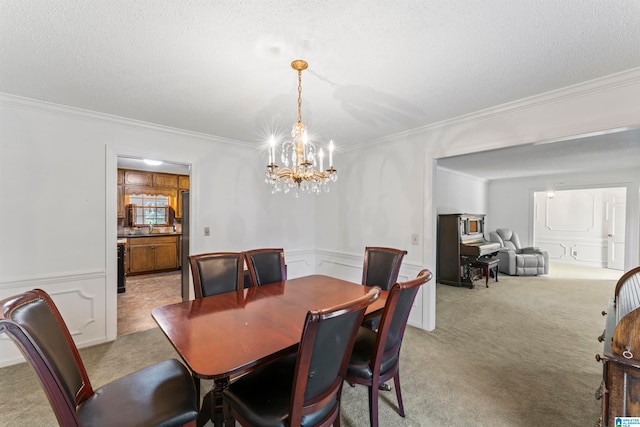 carpeted dining area featuring a chandelier, a textured ceiling, and crown molding