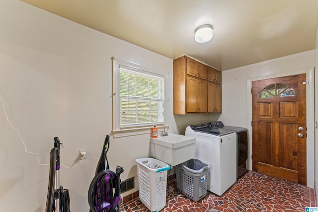 laundry room featuring cabinets and washing machine and dryer