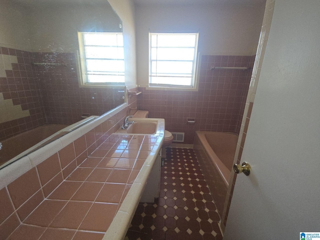 full bath featuring toilet, vanity, visible vents, tile walls, and tile patterned floors